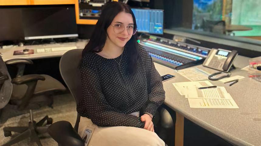 Chloe Hunt sitting at work desk smiling.