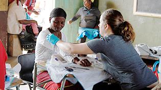 Female nursing student helps an African male